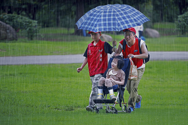 吴斌 《义工冒雨送残障孩童》 中国广东.jpg